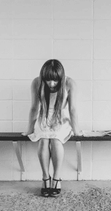 Employee Mental Health Showing Woman Sitting on Bench Looking at her Feeth looking at her feet