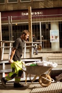 Construction worker pushing a wheelbarrow up a ramp. Willful Misconduct fired without notice and severance