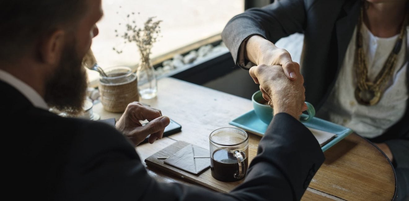 Man & Woman shaking hands over a coffee | Commission Sales Agents