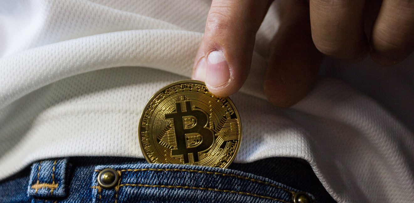 Bonus Pay | Man putting a shiny coin in his back jean pocket