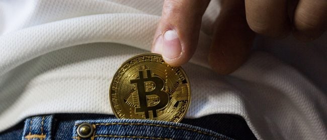 Bonus Pay | Man putting a shiny coin in his back jean pocket